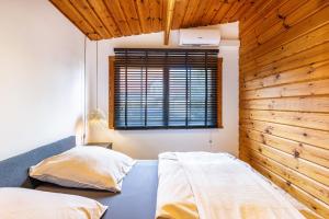 StarzachLa Casa Holzwiesen的卧室设有两张床铺和木墙