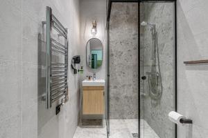 莫雷泰Molėtairesort的带淋浴、盥洗盆和镜子的浴室