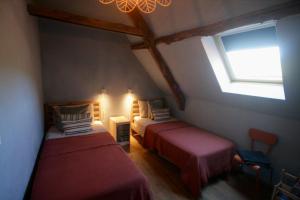 Saint-Pierre-ToiracGite Bellevue的阁楼卧室设有两张床和窗户。