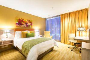 波哥大波哥大理想国酒店的配有一张床和一张书桌的酒店客房