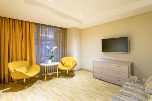 波哥大波哥大理想国酒店的酒店客房带一张床、一台电视和椅子