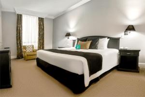 基多丹卡尔顿基多酒店的酒店客房带一张大床和一把椅子