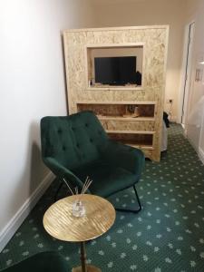 科克Charming 1-Bed Apartment in Cork的客厅配有绿色椅子和桌子