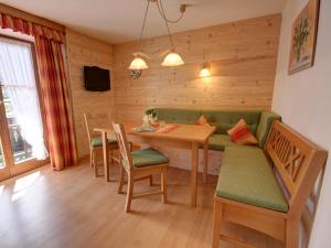 因泽尔Hörlhof - Chiemgau Karte的一间带桌子和绿色沙发的用餐室