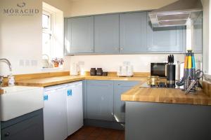 KinghornLinton的厨房配有蓝色橱柜和台面