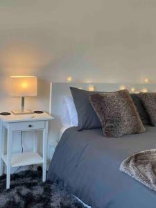 海华德希思Lavender Lodge - Near Shops & with Free Parking的一间卧室配有一张床和一张带台灯的桌子