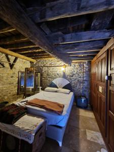 KaracasuHelvacılar Konağı的一间卧室设有两张床和石墙