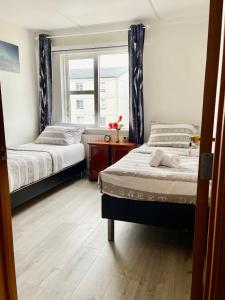 Ytri-NjarðvíkG-1215 apartment的一间卧室设有两张床和窗户。