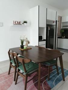 Bandar PenawarRatuSpaQ Home Desaru Utama Residence Apartment的厨房里配有一张木桌和椅子