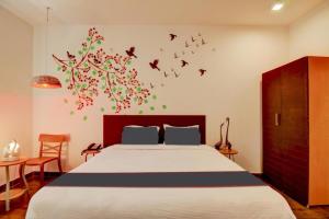 ChandrāvatiRoyal Casa - Asra Hotel的卧室配有一张墙上鸟床