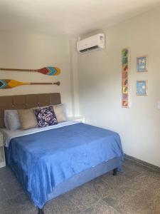 瓜拉派瑞Segunda Casa- Seu cantinho na Praia do Morro em Guarapari - Quartos suítes 2 até 4 pessoas的一间卧室配有一张带蓝色毯子的床