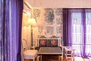 雅典Visionery apt in Pagrati的一间卧室配有紫色窗帘和一张带桌子的床