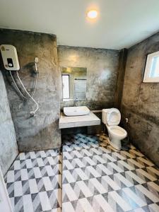 Ban Wang Dinริมยมรีสอร์ท的浴室配有卫生间、盥洗盆和淋浴。
