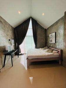 Ban Wang Dinริมยมรีสอร์ท的一间卧室配有一张床、一个窗口和一张书桌