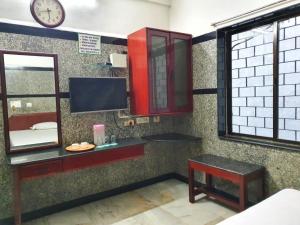 钦奈HOTEL GREENS - Puratchi Thalaivar Dr M G Ramachandran Central Railway Station Chennai的浴室设有镜子、桌子和时钟