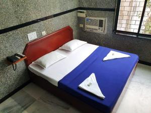钦奈HOTEL GREENS - Puratchi Thalaivar Dr M G Ramachandran Central Railway Station Chennai的一间卧室配有一张带蓝白色毯子的床