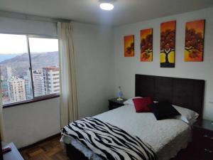 拉巴斯APARTAMENTO PRIVADO Piso 20a, CENTRICO, CERCA EMBAJADA USA, TELEFERICO, MALLS, VISTAS 360 y ZONA SEGURA的一间卧室设有一张床和一个大窗户