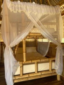 MayapoPlaya Escondida Mayapo的一张带华盖的木床和白色窗帘