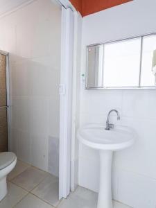 卡达斯诺瓦斯Pousada Caldas Novas的白色的浴室设有水槽和卫生间。