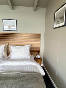 伊卢利萨特Glacier Lodge Eqi的卧室配有一张白色大床和木制床头板