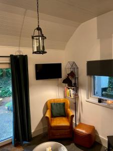 安纳斯考尔Railway cottage Annascaul的客厅配有椅子和电视