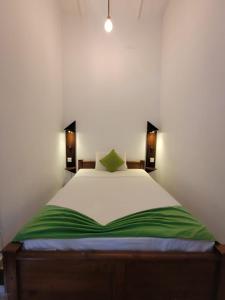 卡图纳耶克The Empyrean Airport Transit Hotel的卧室配有带绿色床单的大型白色床