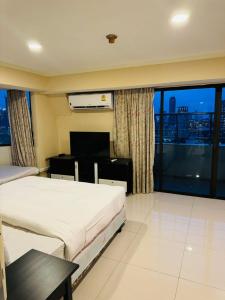 曼谷Omni Tower Sukhumvit Nana by Direct Rooms的酒店客房设有两张床和大窗户。