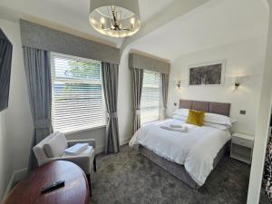 斯塔福德ABBEY HOTEL的一间卧室配有一张床、一把椅子和窗户。