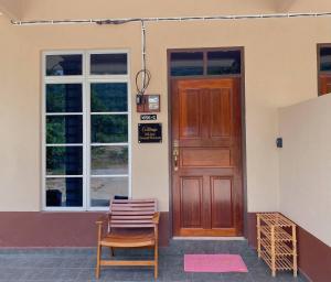 Kampong Gong BalaiNSJay Guest House的一座带木门和椅子的房子