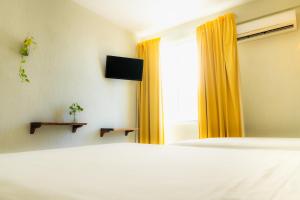 切图马尔Caribe Princess的一间卧室设有床和黄色窗帘的窗户