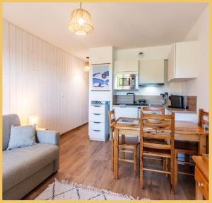 莱热Appartement T2 Sublime situé à LES GETS的厨房以及带桌子和沙发的客厅。