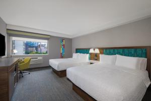 多伦多Hampton Inn & Suites by Hilton Toronto Downtown的酒店客房设有两张床和电视。