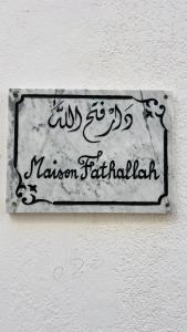 马赫迪耶Maison Fathallah的墙上的标有清真寺名称的标志