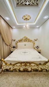 马赫迪耶Maison Fathallah的吊灯房间中的一张金色床