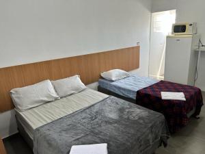圣保罗Studio mobiliado na Vila Guilherme - São Paulo/SP的酒店客房配有两张床和一台冰箱