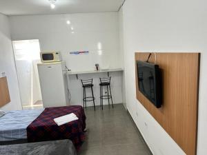 圣保罗Studio mobiliado na Vila Guilherme - São Paulo/SP的一间带一张床的房间和一间带电视的厨房