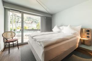 图恩Hotel Aare Thun的一间卧室设有一张大床和一个大窗户
