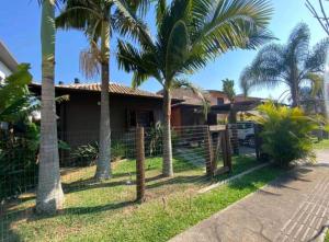 加罗帕巴Aconchegante e charmosa casa的前面有棕榈树的房子