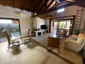 加罗帕巴Aconchegante e charmosa casa的客厅配有玻璃桌和椅子