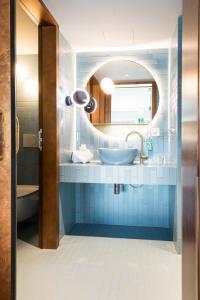 图恩Hotel Aare Thun的蓝色的浴室设有水槽和镜子