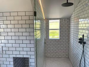 GodafossHótel Goðafoss Fosshóll的浴室设有白色瓷砖墙壁和窗户。