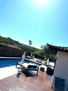 布希奥斯Villa Ferradura Mar的一个带椅子的庭院和一个游泳池