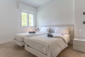 卡尔切拉尼卡阿拉戈La Gemma sul Lago的一间卧室设有两张带白色床单的床和窗户。