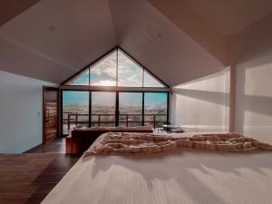 恩塞纳达港7 Valles的一张大床,位于带大窗户的房间里