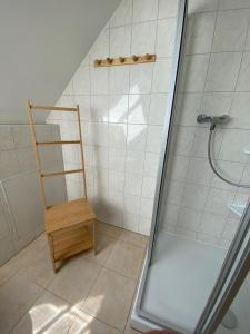 克劳斯多夫Ferienhaus am Gutspark 3, Klausdorf, ca 250 m bis zur Badestelle的带淋浴的浴室和木椅