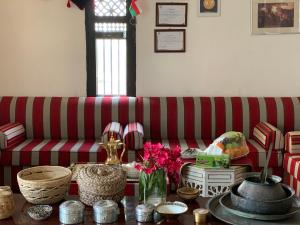Fulayj al Mashāʼikh金棕榈绿洲酒店的客厅配有红色和白色条纹沙发
