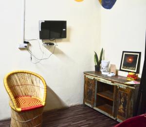 斋浦尔Housetel的客房设有电视、椅子和书桌。