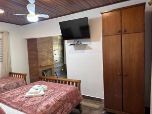 圣安东尼奥-杜皮尼亚尔里坎多奥奎迪斯旅馆的一间卧室配有两张床和一台平面电视