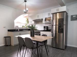 克萨尔特南戈Apartamento acogedor y minimalista.的厨房配有桌子和不锈钢冰箱。