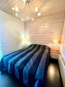 耶姆赛Aurinkopaikka 4 Himos的卧室配有一张床铺,位于带木墙的房间内